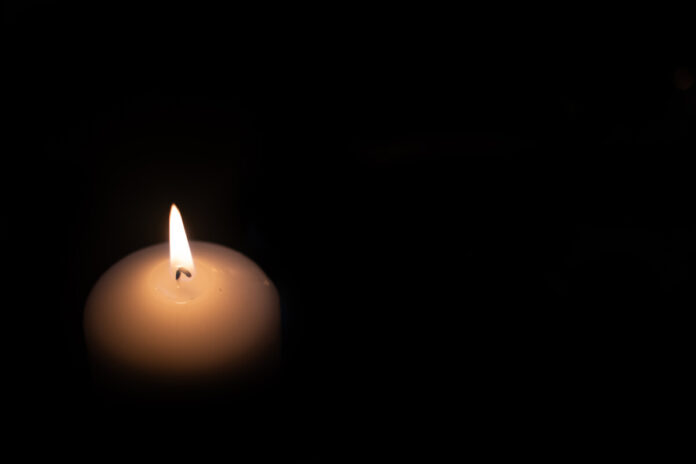 Fourth advent, four candles - candlelight on dark brown panorama background - advent banner. Horizontal banner for homepage. Template for greeting cards, funeral cards and obituaries.