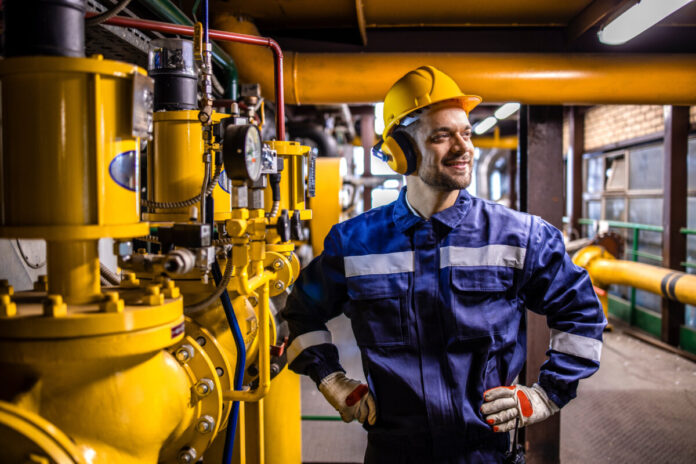 Power generation plant worker controlling crude oil and gas proc