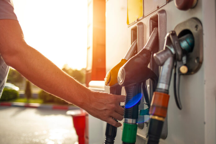 Man hand holding a fuel pump at a station. Detail of a hand hold
