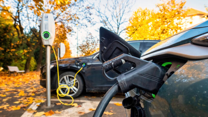 Two charging cars at a charging station in autumn