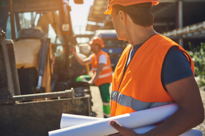 Employees of construction company are working outdoor