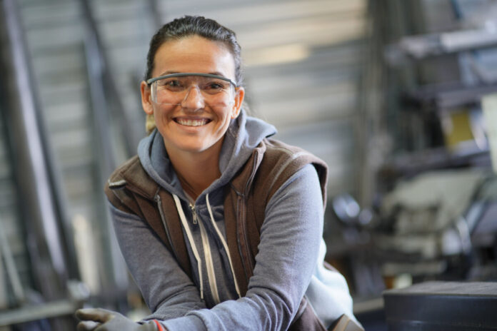 Woman apprentice training in metalwork workshop