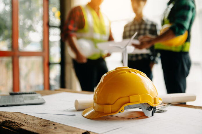 Engineer teams meeting working together wear worker helmets hardhat on construction site in modern city.Asian industry professional team.