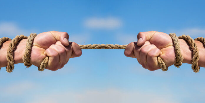 Rope, cord. Hand holding a rope, climbing rope, strength and determination. Rescue, help, helping gesture or hands. Conflict tug of war. Two hands, helping hand, arm, friendship