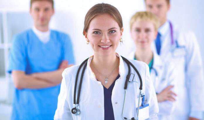 Attractive female doctor in front of medical group